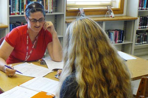 Ms. Glover works with a student on physics in the Academic Assistance Center in the library.
