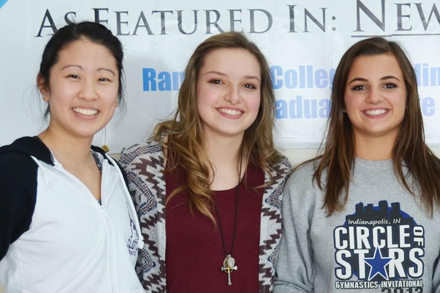 Maddy Kim, Kat Schaffer, and Kira Karlblom pose for a picture during the state send-off parade before the state gymnastics meet.