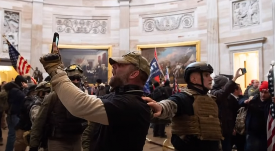 This screenshot from a PBS NewsHour video from inside the Capitol on January 6, 2020 shows a man taking a picture of himself inside the building. Social media photos and videos have since led to arrests.